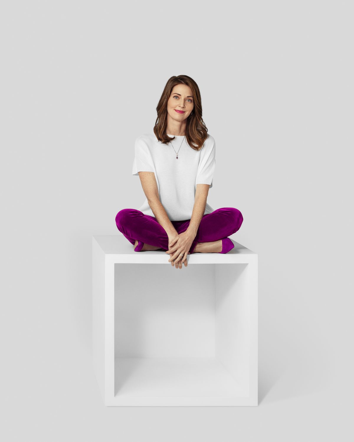 Woman in white t-shirt sitting on top a white box